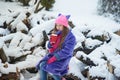 girl holding cup of hot drink and sitting on grass. female hands holding hot chocolate with marshmallow in a red mug. Royalty Free Stock Photo