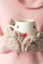 Girl holding cup with snowflakes close up on light background.Girl hands in teal gloves holding a mug with hot cocoa, tea or Royalty Free Stock Photo