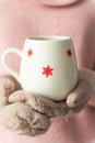 Girl holding cup with snowflakes close up on light background.Girl hands in teal gloves holding a mug with hot cocoa, tea or Royalty Free Stock Photo