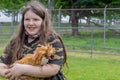 Girl holding a cute padovana chicken outside.