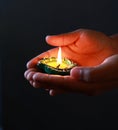 A girl holding diya in her hand to celebrate diwali and dhanteras