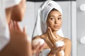 Girl Holding Face Cream Product Hydrating Skin In Bathroom Royalty Free Stock Photo