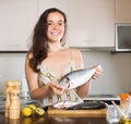 Girl holding fish at kitchen Royalty Free Stock Photo