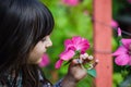 Closeup of pretty Little child Girl kid holding and smelling flowe Royalty Free Stock Photo