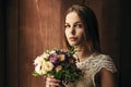 Girl holding flowers in hands, young beautiful bride in white dress holding wedding bouquet, bouquet of bride from rose cream spra Royalty Free Stock Photo