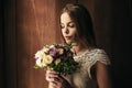 Girl holding flowers in hands, young beautiful bride in white dress holding wedding bouquet, bouquet of bride from rose cream spra Royalty Free Stock Photo