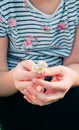 A girl holding in front of her a small bouquet of small field daisies