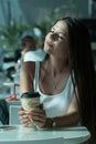 Girl is holding a glass of coffee in airport`s business lounge with aircraft Royalty Free Stock Photo