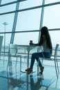 Girl is holding a glass of coffee in airport`s business lounge with aircraft Royalty Free Stock Photo