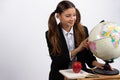 Girl holding globe, looks at it near book, apple. White background with space Royalty Free Stock Photo