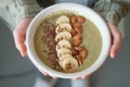 Girl holding a green smoothie bowl. vegans