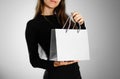 Girl holding a grey gift bag. Close up. Isolated background