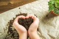 The girl is holding the ground. The girl will transplant potted plants at home. Earth, seedling, Spring, hands, the concept of pro