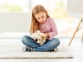 Girl holding guinea pig on the floor Royalty Free Stock Photo