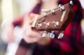 Girl holding guitar. Focus on the head of guitar Royalty Free Stock Photo