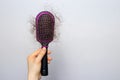 The girl is holding a hairbrush with lost hair. Hair loss, care and treatment. Trichologist, trichology. Banner with