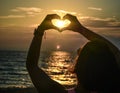 Girl holding hands in heart shape at beach Royalty Free Stock Photo