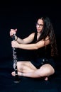 A girl holding her clarinet music instrument. Figure against a black background. Royalty Free Stock Photo