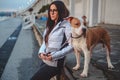 Girl holding her dog on a leash while enjoying sunset