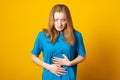 Girl holding her stomach and frowns. Teenage girl has a stomach ache. Female writhes in pain Royalty Free Stock Photo