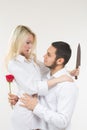 Girl holding knife traitor. man with rose in his hand.