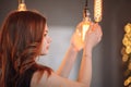 Girl holding a large incandescent lamp in the studio in her hands