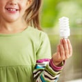 Girl holding light bulb Royalty Free Stock Photo