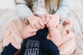 A girl holding little caucasian baby`s feet in her hands close-up Royalty Free Stock Photo