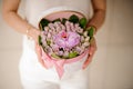 Girl holding a little white spring basket of tender violet roses and one orchid Royalty Free Stock Photo