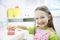 Girl holding model of human jaw with dental braces