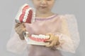 Girl holding model of teeth, jaw. training, teaching, prevention children oral hygiene. child dentistry. kid tooth treatment Royalty Free Stock Photo