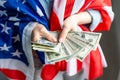 Girl holding money on American flag background. Royalty Free Stock Photo