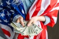 Girl holding money on American flag background. Royalty Free Stock Photo