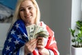 Girl holding money on American flag background. Royalty Free Stock Photo