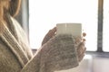 The girl holding the mug of hot coffee in her tender hand. in the morning soft sunlight. Side view Royalty Free Stock Photo