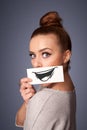 Girl holding paper with funny smiley drawing on gradient background Royalty Free Stock Photo