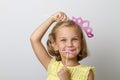 Girl holding paper party sticks on a solid background