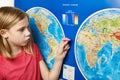 Girl holding paper plane on world map
