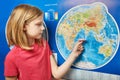 Girl holding paper plane on world map