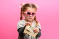 Girl holding paper US dollars, rich and happy child, child and money.