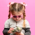 Girl holding paper US dollars, rich and happy child, child and money.