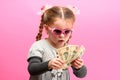 Girl holding paper US dollars, rich and happy child, child and money.