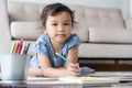 The girl holding a pencil and smiling.aisan Girls are drawing happily in at home