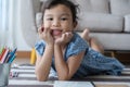 The girl holding a pencil and smiling, This one asian little girl is playing in the living room at home .she smile very happily