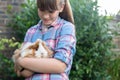 Girl Holding Pet Guinea Pig Outdoors In Garden Royalty Free Stock Photo