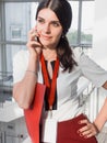 The girl is holding the phone in her hands. Beautiful Smiling Businesswoman is calling by phone. Portrait of Business Woman With a Royalty Free Stock Photo