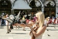 Girl holding pigeons in Piazza San Marco Venice Italy.