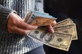 girl holding a pile of wads of money dollar bills to buy Royalty Free Stock Photo