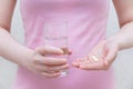 The girl is holding a pill and a glass of water Royalty Free Stock Photo