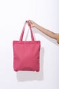 Girl is holding pink bag canvas fabric for mockup blank template on white background. global warming concept